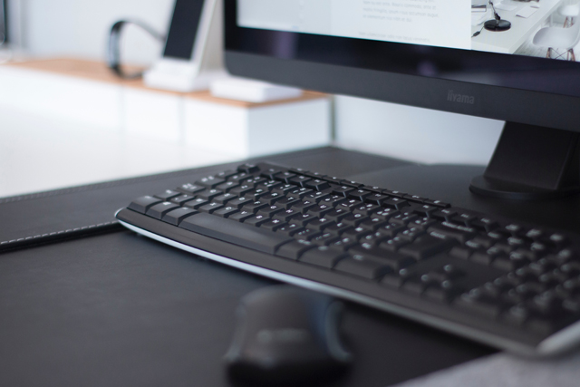Schwarzer PC auf hellem Tisch PC-Monitor mit Tastatur und Maus
