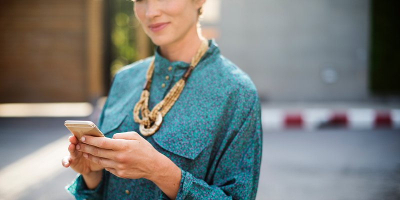 Junge Frau mit Smartphone in der Hand