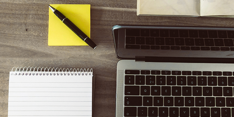 Laptop auf Tisch mit Stift und Zettel