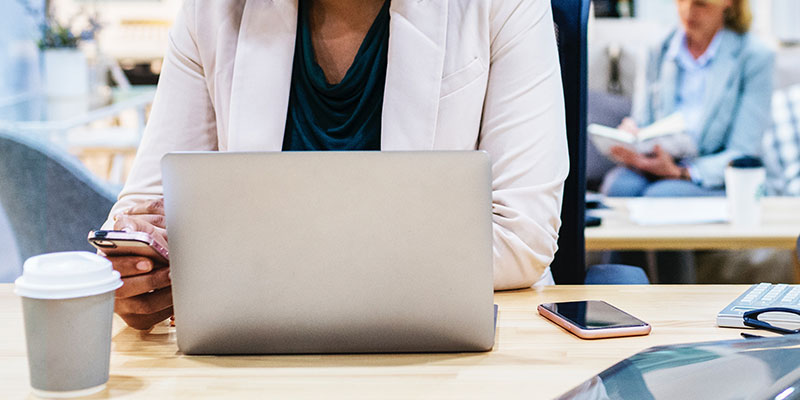 Frau mit Laptop und Smartphone