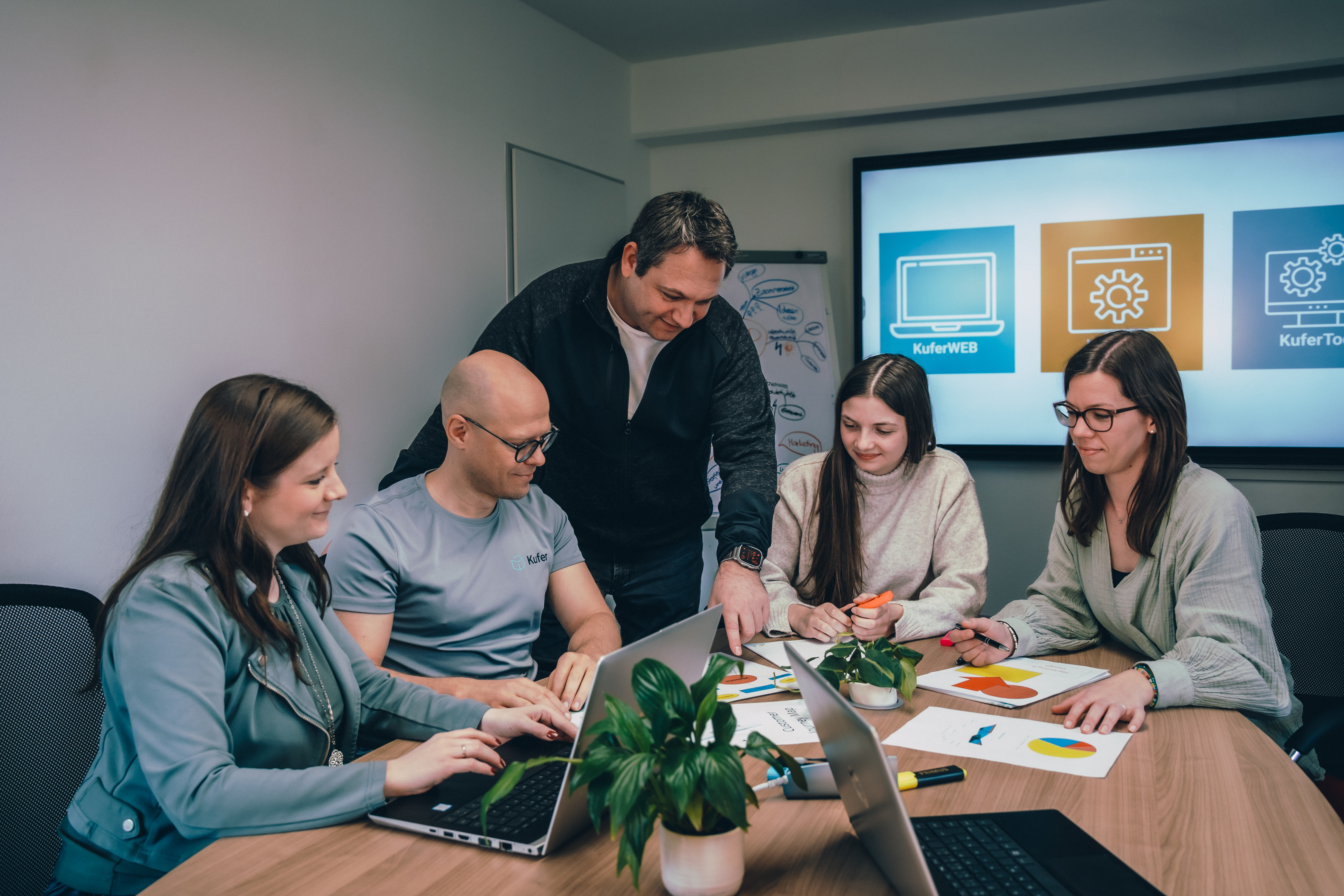 Team arbeitet gemeinsam an einem Tisch in einem Besprechungsraum